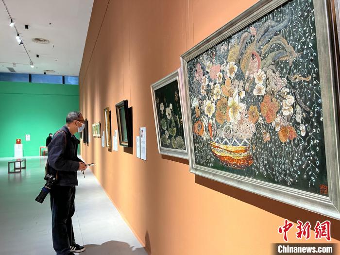 圖為民眾圍觀工藝美術大師及非遺代表性傳承人作品?！＄婌綌z